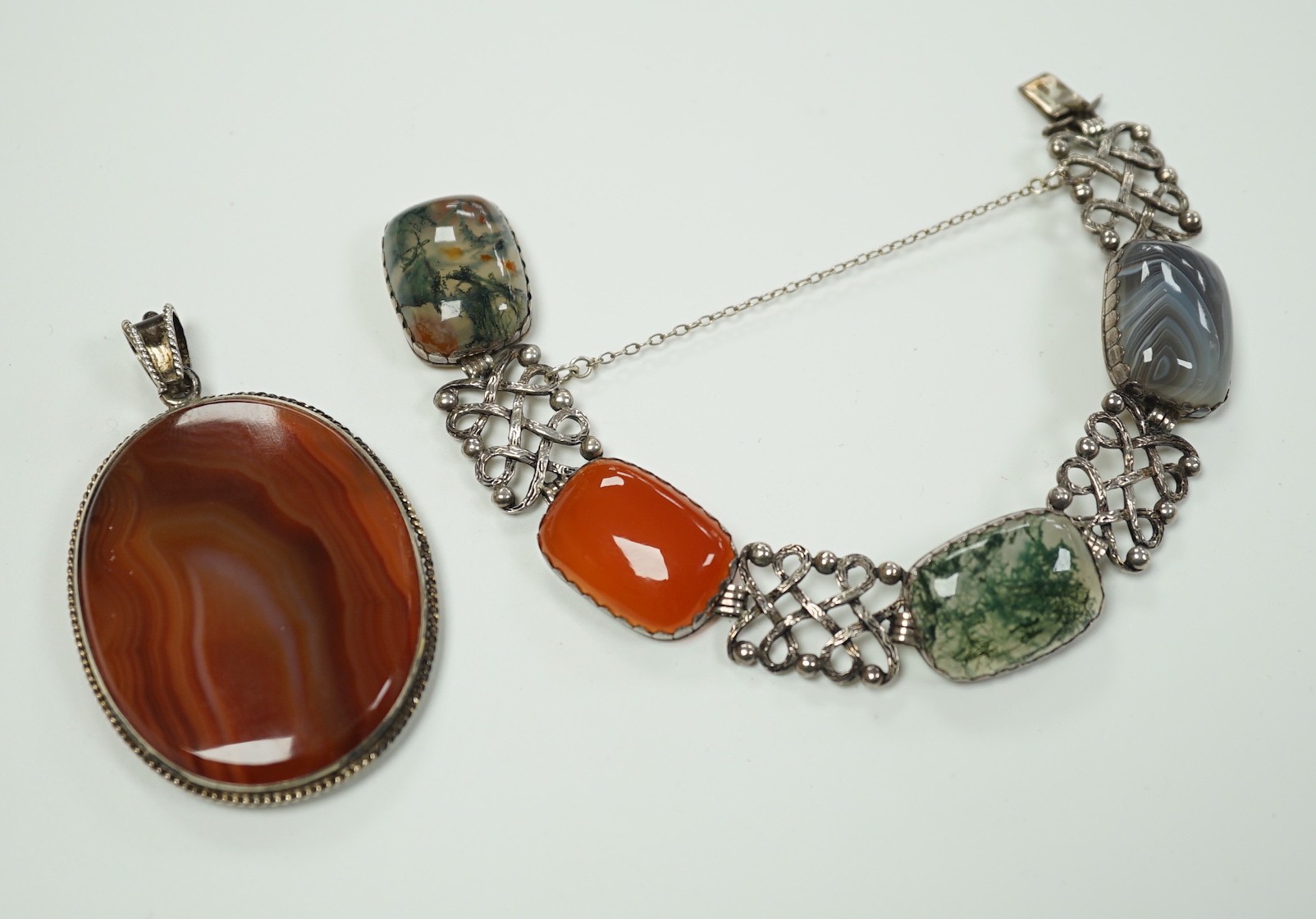 A pierced white metal and four stone agate set bracelet, 18.5cm and a white metal and banded agate set oval pendant.